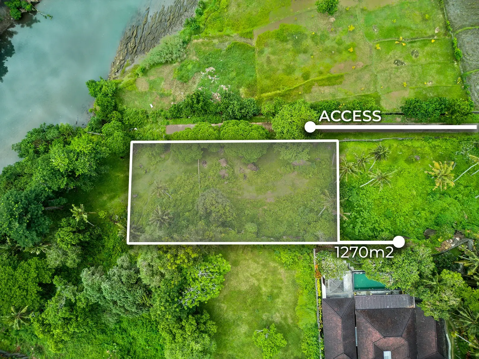 Drone views of 1,270m2 riverside land for sale in Pulukan Bali featuring lush tropical surroundings, river access, ocean views, and nearby villas.