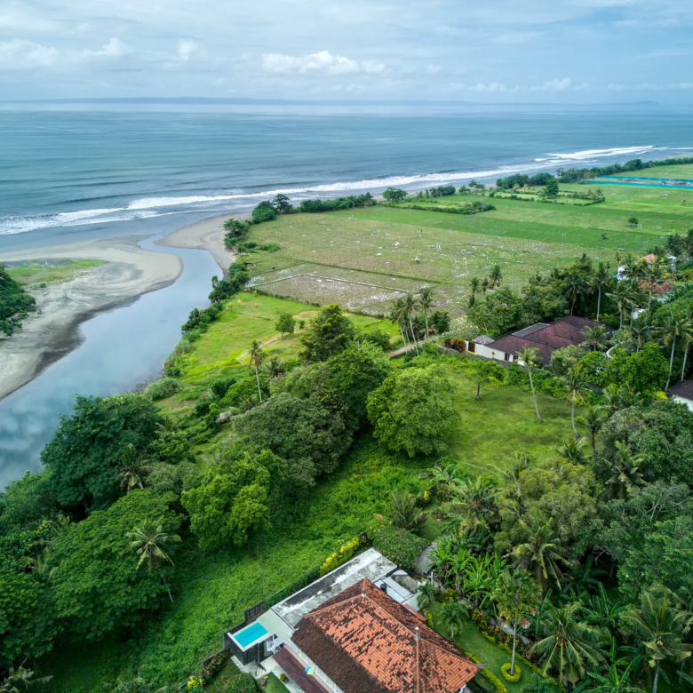 High-angle ocean and river panorama showing Pulukan greenbelt land and neighboring villas.