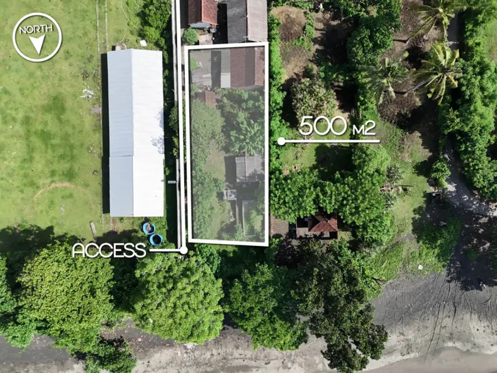 Top-down drone image showing a 500 m² beachfront land plot in West Bali with marked boundaries, private access, and mature trees
