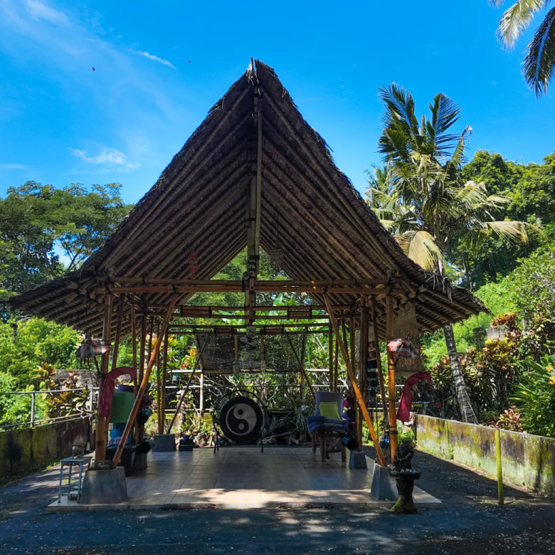 Traditional bamboo pavilion in West Bali surrounded by lush tropical garden, showcasing natural architecture and peaceful lifestyle setting.