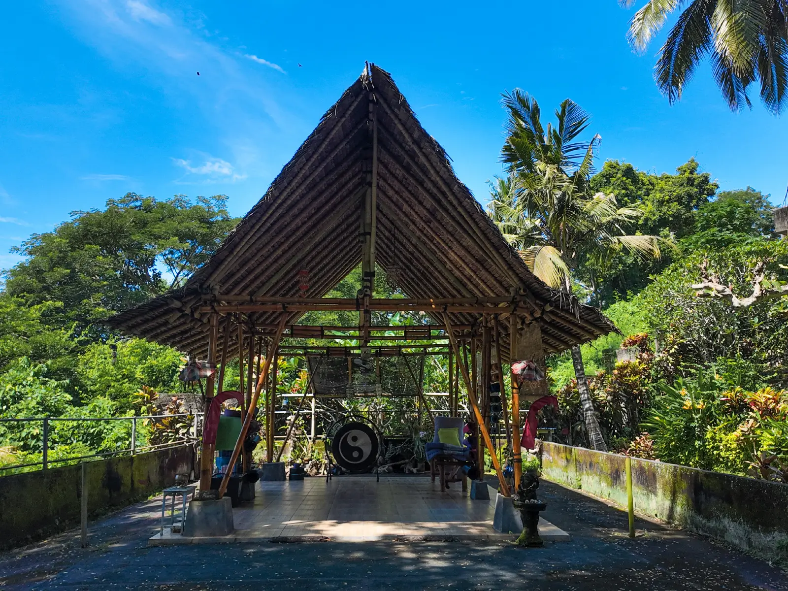 Traditional bamboo pavilion in West Bali surrounded by lush tropical garden, showcasing natural architecture and peaceful lifestyle setting.