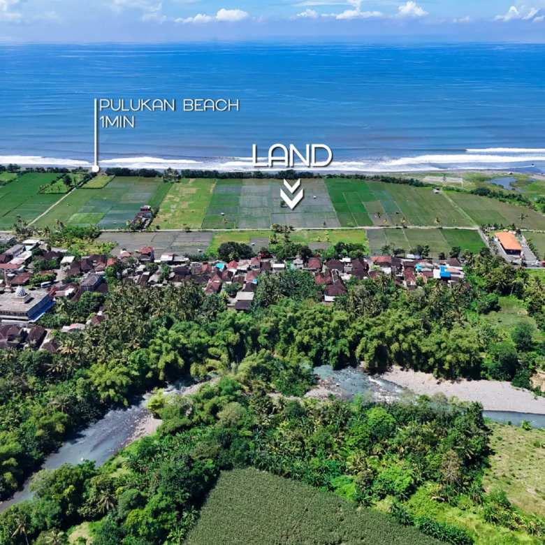 Drone view showing land for sale in West Bali located 1 minute from Pulukan Beach, bordered by rice terraces and village houses with ocean frontage