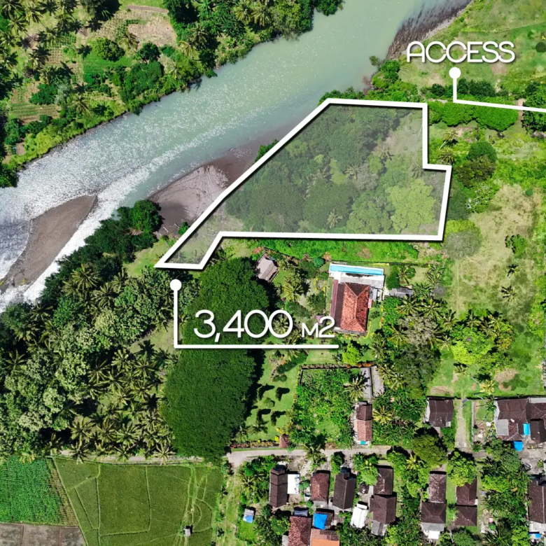 Top-down drone image of a 3,400 m² riverfront land plot in West Bali, with marked boundaries, private access, and lush tropical surroundings