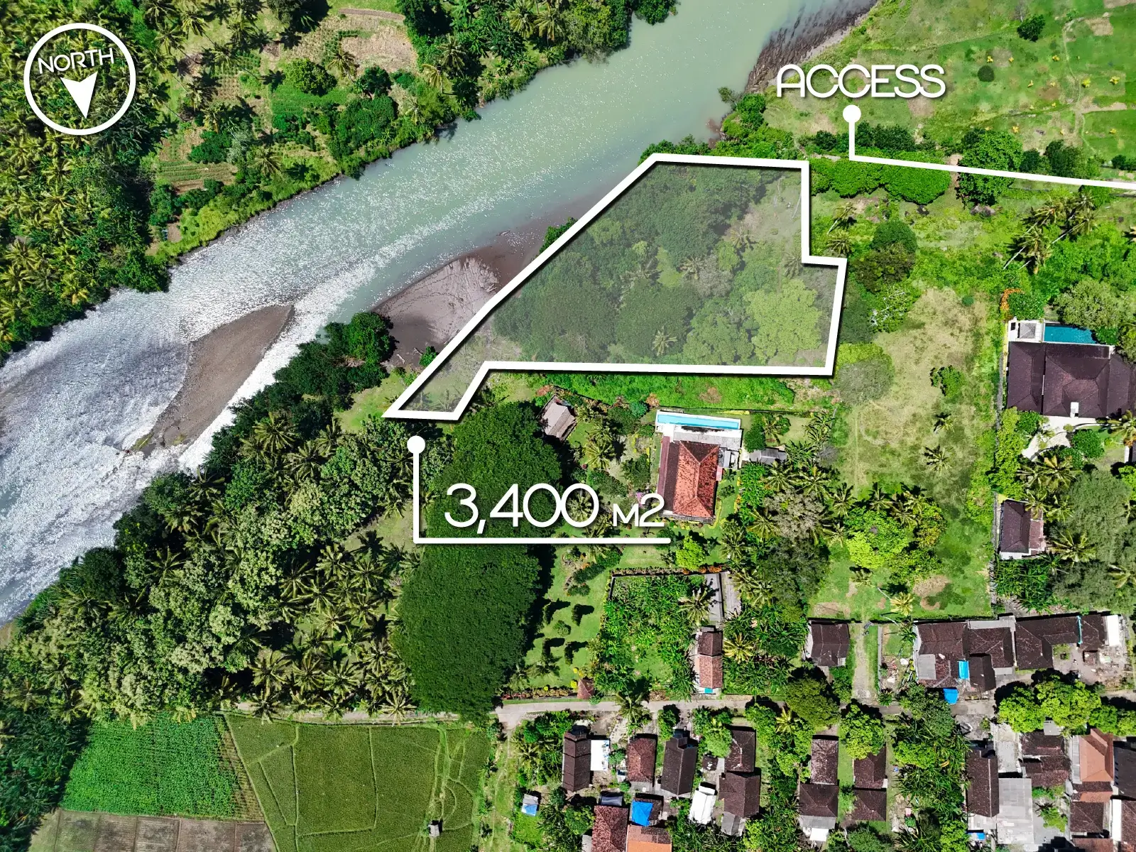 Top-down drone image of a 3,400 m² riverfront land plot in West Bali, with marked boundaries, private access, and lush tropical surroundings