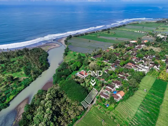 Aerial view of land near river and village in West Bali, showing green landscape with land plot marked close to the coastline.