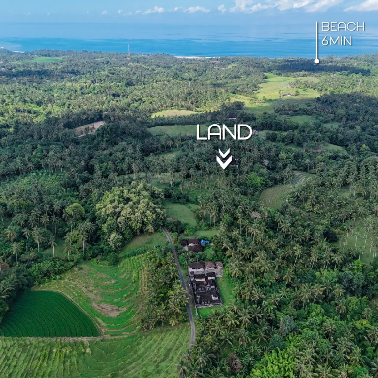 Aerial view of West Bali showing lush green hills, ocean in the background, and the marked land for sale located just 6 minutes from the beach