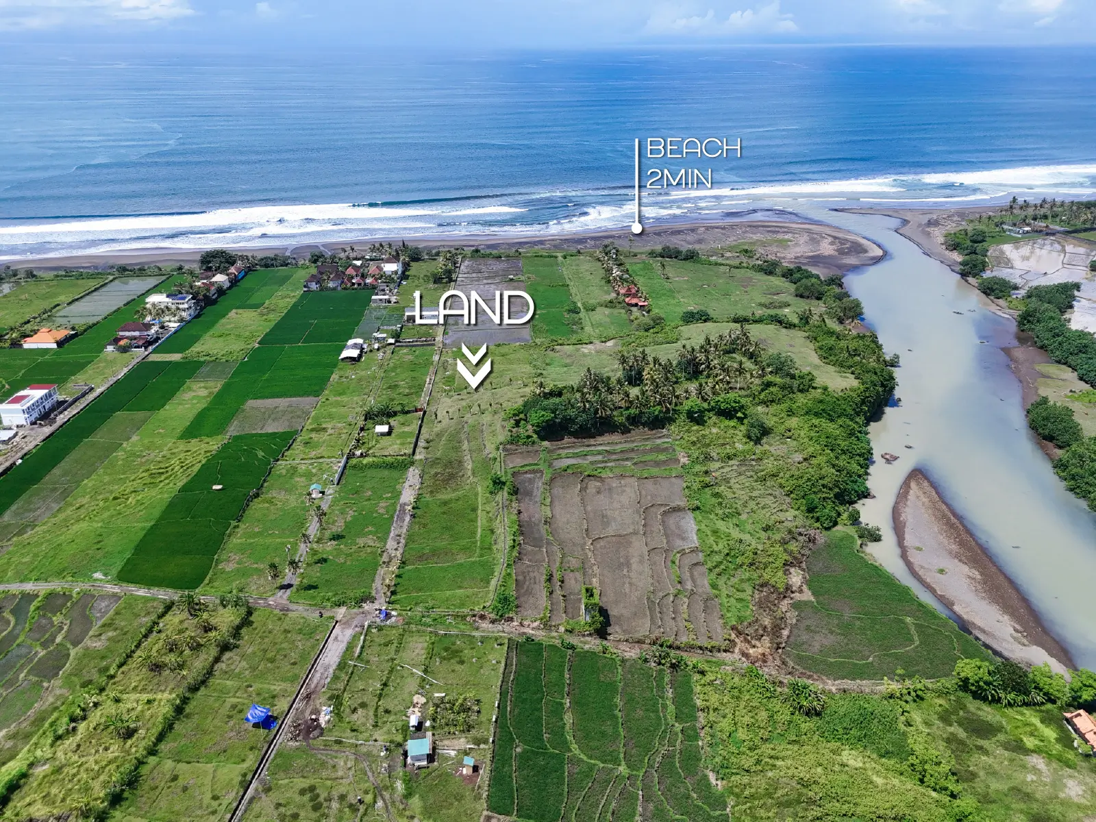 Aerial shot of West Bali land for sale located just 2 minutes from the beach, with rice fields, coastline, and river estuary in view