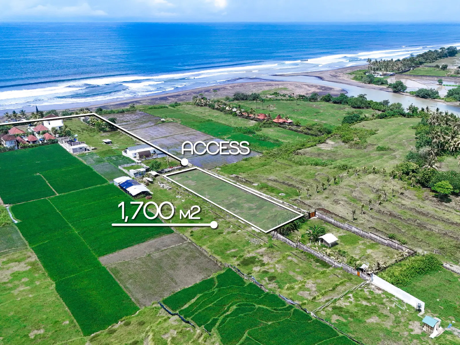 Aerial view marking a 1,700 m² land plot in West Bali with private access road, rice field surroundings, and ocean views