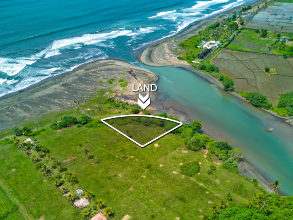 Top-down drone image of a 1,534 m² riverfront land plot in West Bali, showing curved beachfront boundary, private access road, and turquoise river frontage.