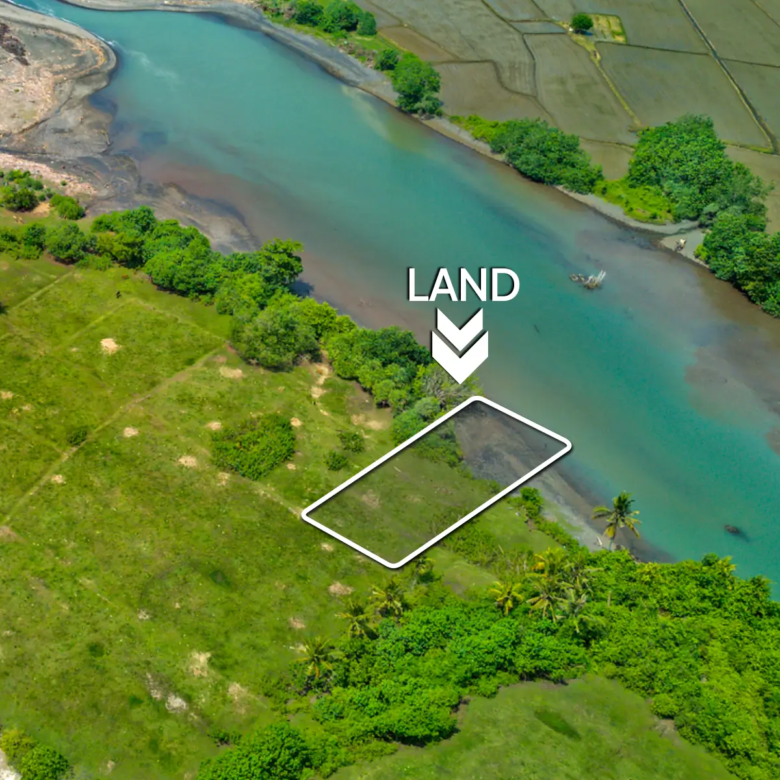erial view of a 1,000 m² riverfront land plot in West Bali, located just steps from the beach with turquoise lagoon water, ocean waves, and surrounding green fields.